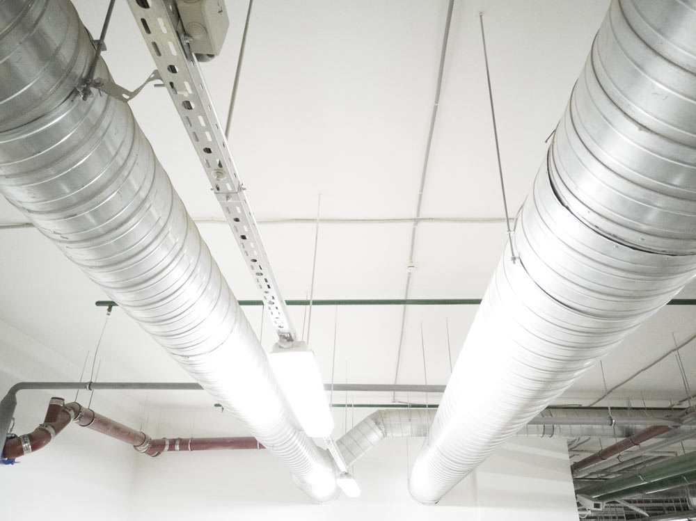 Ventilationsrör i metal som hänger i taket